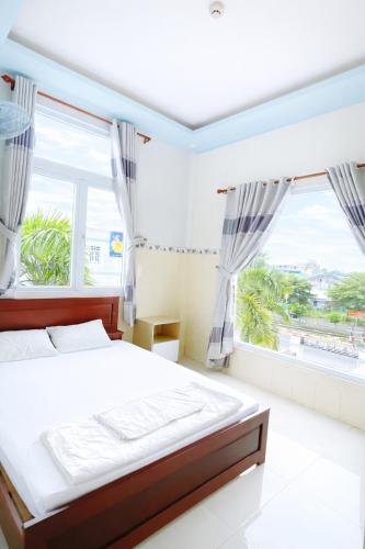 a bedroom with a bed and a large window at Lê Thuận Hotel in Lai Vung