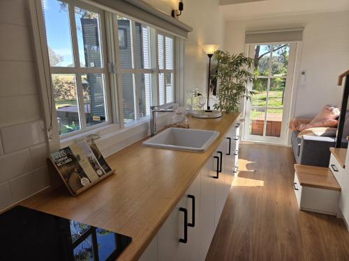 a kitchen with a sink and a counter with windows at Sale Caravan Park in Sale