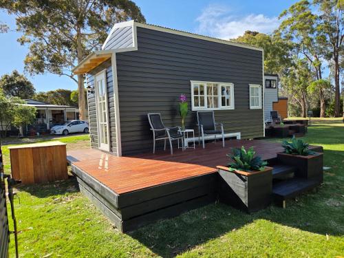 a tiny house with a deck in a yard at Sale Caravan Park in Sale