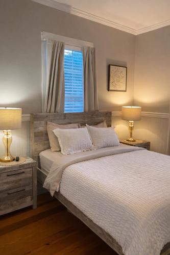 a bedroom with a bed with two lamps and a window at Relaxing Poolside Condo in Savannah
