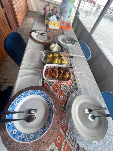 a long table with plates and bowls of food on it at Raja Ampat Holidays in Besir