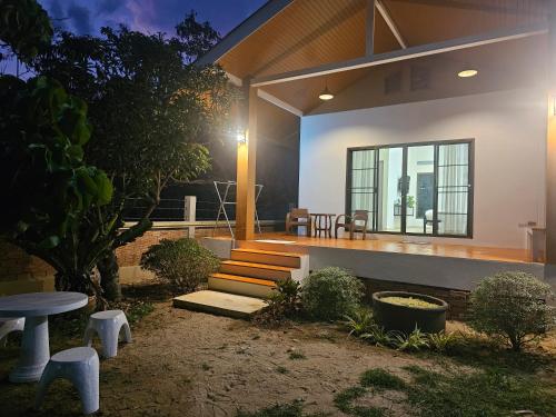a house with a porch with a bench and a table at Khiri&Kiwi homestay in Ban Mae Rim Nua