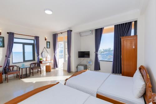 a hotel room with two beds and a television at Truong An Hotel in Vung Tau