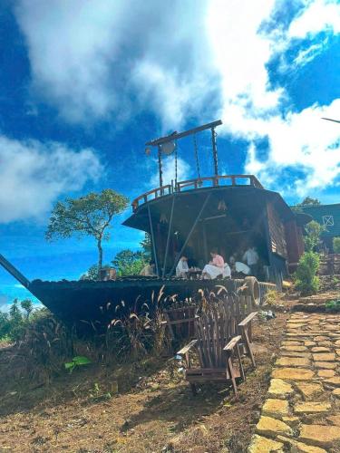 a boat sitting in the grass with a bench at An House in Xuân Trường