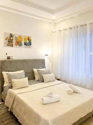 ein Schlafzimmer mit zwei Betten, auf denen Handtücher liegen in der Unterkunft Meublés tout confort à Makepe - Immeuble KOLA - Groupe Électrogène in Douala