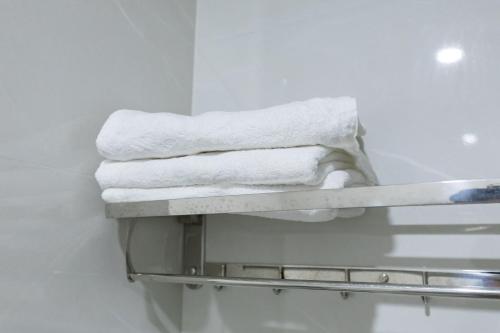 a pile of towels on a towel rack in a bathroom at Truong An Hotel in Vung Tau