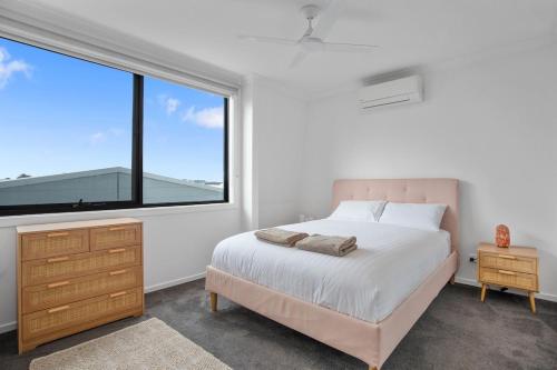 a bedroom with a bed and a large window at Williamstown Townhouse in Williamstown