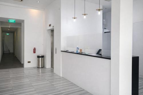 an office lobby with white walls and a counter at A Hotel Dickson, Stay From 9PM To 8AM in Singapore