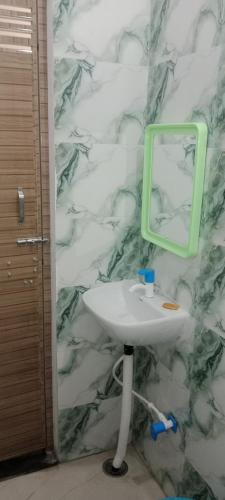 a bathroom with a sink and a mirror on a wall at Hari Sharnam Residency in Mathura