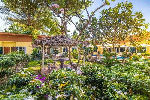 a garden with a table and a pavilion at Tongtong Garden Holiday Hotel普吉岛通通花园酒店 in Rawai Beach