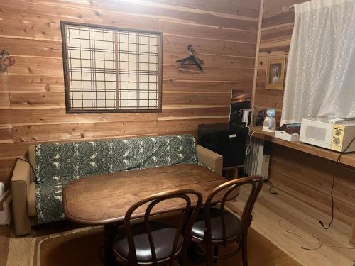 a kitchen with a table and chairs in a room at 天女座 Tennyoza in Kumano