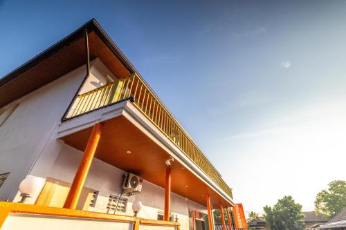 a building with a balcony on the side of it at Tongtong Garden Holiday Hotel普吉岛通通花园酒店 in Rawai Beach