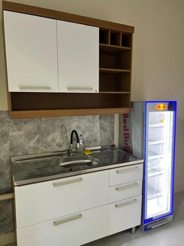 a kitchen with a sink and a refrigerator at Pousada do Leo in Olinda