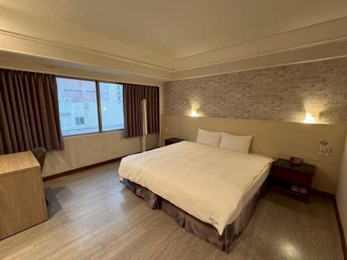 a hotel room with a bed and a brick wall at Long Siang Hotel in Kaohsiung
