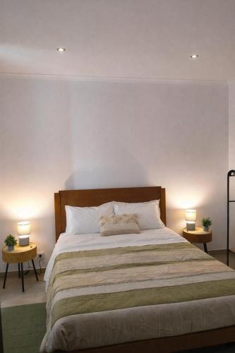 a bedroom with a large bed with two lamps at Alojamento dos cagarros in São Sebastião