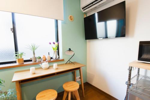a small kitchen with a table and two stools at Near Ikebukuro, Kitchen & Laundry, Fast Wi-Fi, 4min to Station,Many restaurants nearby!! in Tokyo