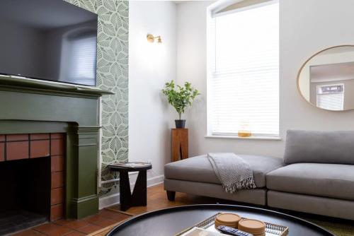 a living room with a couch and a fireplace at Spacious Haven near Busch ABODEbucks in Soulard