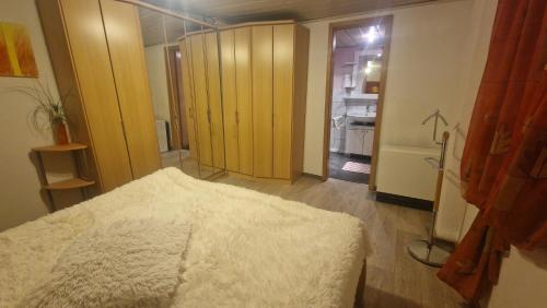 a bedroom with a bed and a hallway with a kitchen at FeWo altes Pfarrhaus in Erndtebrück