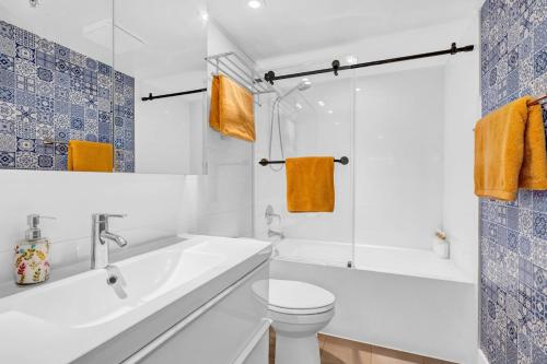 a white bathroom with a toilet and a sink at Casa DT Vancouver - Mexican Theme in Vancouver