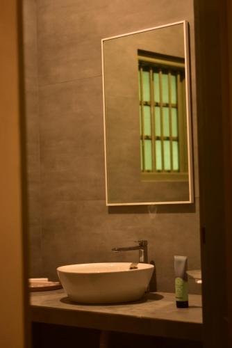 a bathroom with a sink and a mirror at Rain Drops Wellness Villa Deniyaya, Sinharaja in Deniyaya