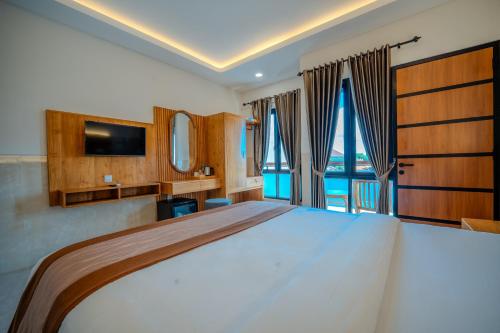 a bedroom with a large bed with a large window at Wana Kubu Suite and Dormitory in Ngurah Rai International Airport