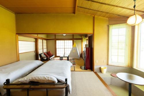 a bedroom with a large bed and a table at Villa Hello Fujisan ヴィラハローフジサン 屋根付きBBQ場 ワンちゃん大歓迎 A220 in Fujiyoshida