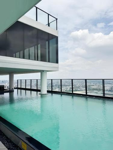 a building with a swimming pool in front of the ocean at Cassia Residence Rama 9 Bangkok in Bangkok