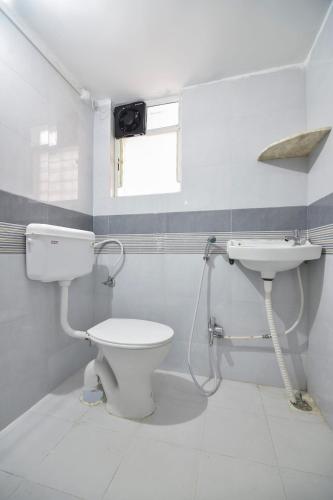 a bathroom with a toilet and a sink at HOTEL O THE G STAY in Chinchwad