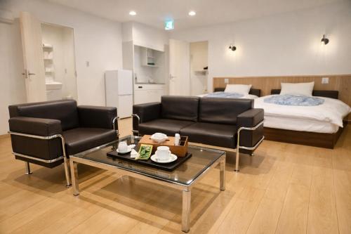 a living room with a couch and a bed at 舒爽旅馆 in Fuefuki