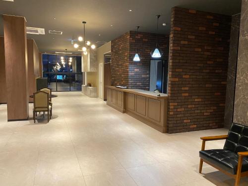a lobby with a brick wall and a waiting area at Hotel Forest Echo 森のこだま