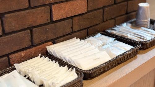 two baskets of cheese on a counter next to a brick wall at Hotel Forest Echo 森のこだま