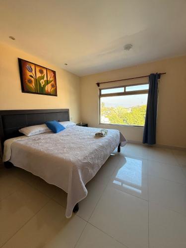 a bedroom with a large bed and a window at Hotel Boutique Los Laureles in Tuxtla Gutiérrez