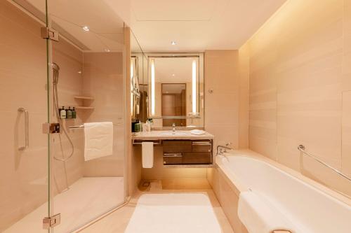 a bathroom with a bath tub and a sink at Shangri-La Songbei, Harbin in Harbin