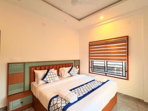 a bedroom with a large bed with a window at Pullat Suites in Kalpetta