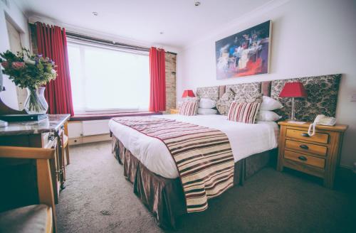 a hotel room with a large bed and a window at Royal Seven Stars Hotel in Totnes