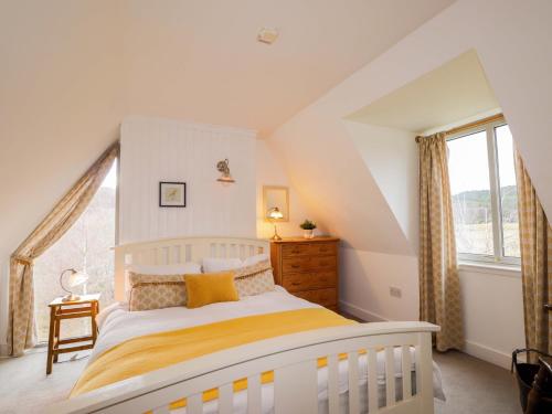 a bedroom with a white bed and a large window at Inshcraig in Kincraig
