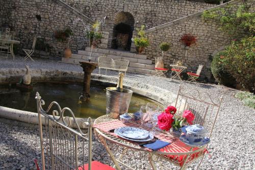 a table with flowers on it next to a pond at Demeure des Vieux Bains in Provins