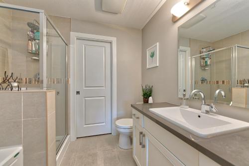 a bathroom with a sink and a toilet and a mirror at Stay In The Okanagan - Copper Sky, West Kelowna in West Kelowna