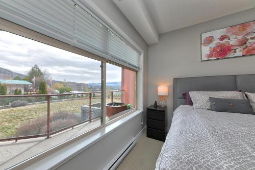 a bedroom with a bed and a large window at Stay In The Okanagan - Copper Sky, West Kelowna in West Kelowna
