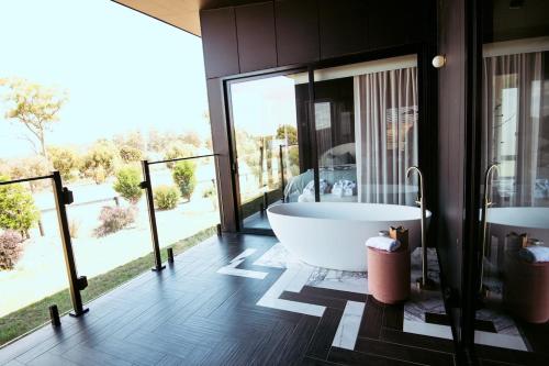 a large bathroom with a tub and a large window at Wherewithal Luxury Suites in Carlton