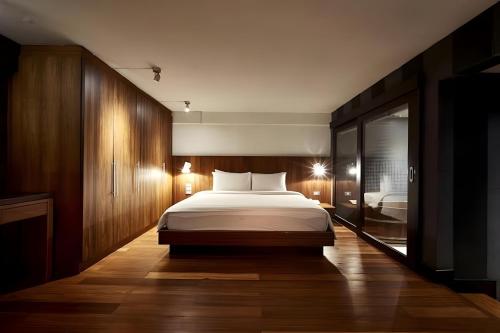 a bedroom with a large bed and a bathroom at Wish Inn Silom - Decho Bangkok City in Bang Rak