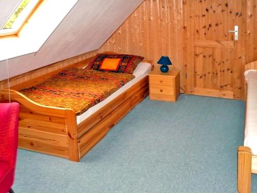 a bedroom with a wooden bed in a attic at Luzie's Hus in Freest