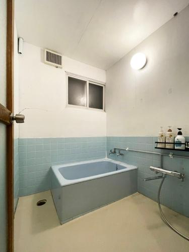 a bathroom with a blue tub in a room at 台町Arun別邸 in Abashiri