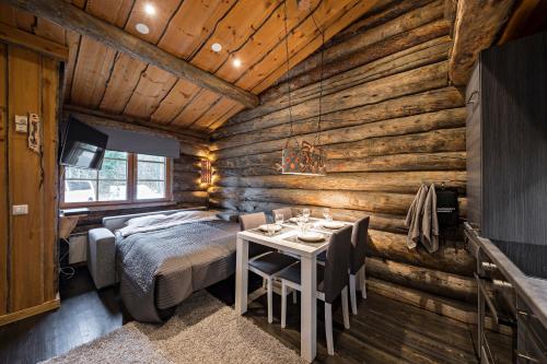 a bedroom in a log cabin with a bed and a table at UnelmaPovi in Ruka