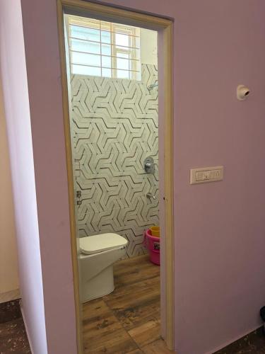 a bathroom with a toilet and a wall at S N Greens in Chik Bānavar