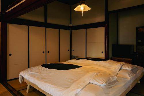a large white bed in a room with cabinets at Minato-no Akari in Hayama