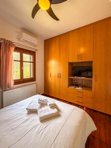 a bedroom with a bed with two towels on it at Villa Maria Amalia in Tsagarada