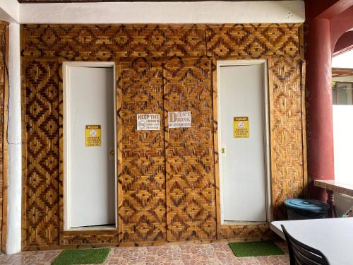 two doors on a wall with signs on them at Nine Clouds Homestyle Accommodation in General Luna