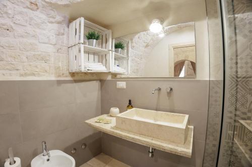 une salle de bains avec un lavabo et un miroir dans l'établissement Pignarè, à Locorotondo