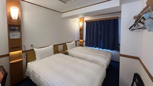 a hotel room with two beds and a window at Toyoko Inn Okinawa Naha Asahibashi Ekimae in Naha